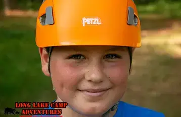 Camper wearing a safety helmet at Long Lake Camp Adventures outdoor activities.