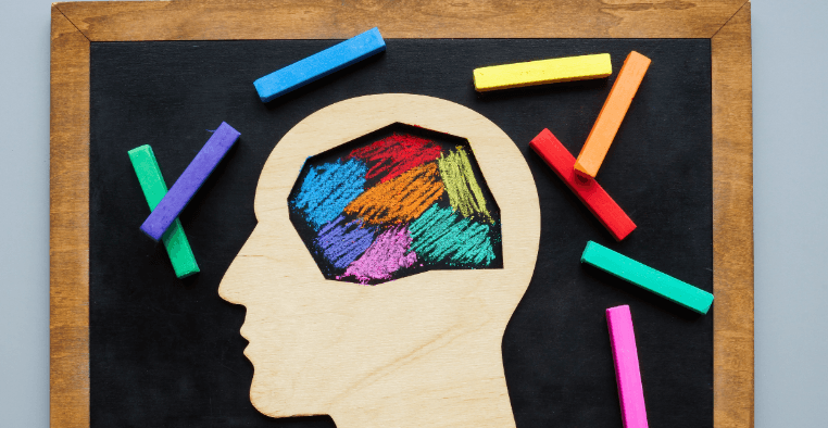 Illustration of a child’s head silhouette with colorful chalk patterns symbolizing neurodiversity and inclusive support for neurodivergent kids at camp.