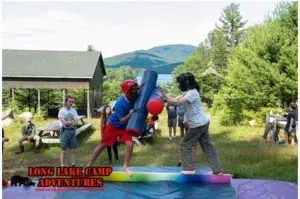 Campers participating in a foam jousting challenge at Long Lake Camp Adventures.